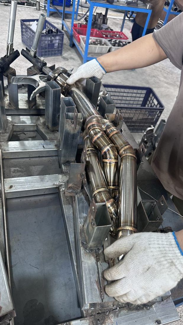 Technician fitting a tacked header into the production jig