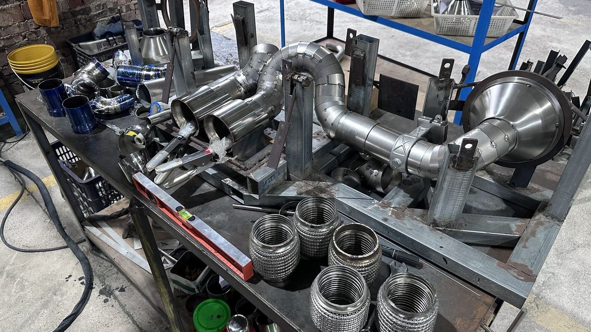 Stainless header with braided flex bellows on a welding jig