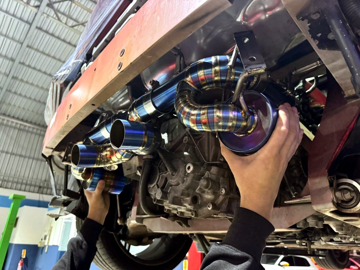 Ferrari 458 Italia underbody with OUCHI titanium exhaust and downpipes being fitted — customer installation
