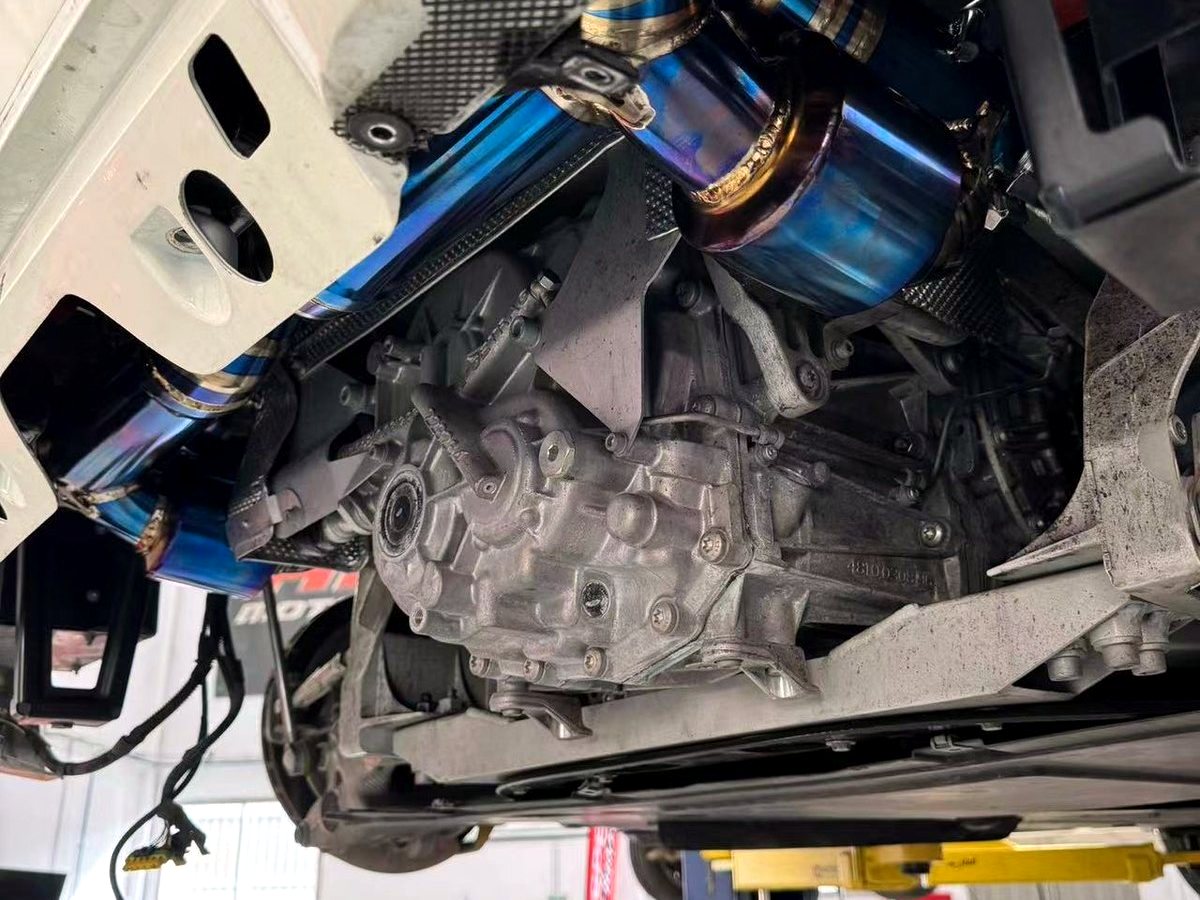 Ferrari 458 Italia underbody with OUCHI heat-tinted titanium exhaust routing — customer installation