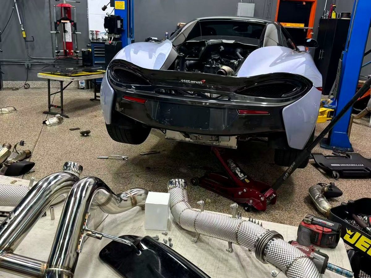 McLaren 570S rear clam off with OUCHI full stainless header and exhaust system on the bench — customer installation