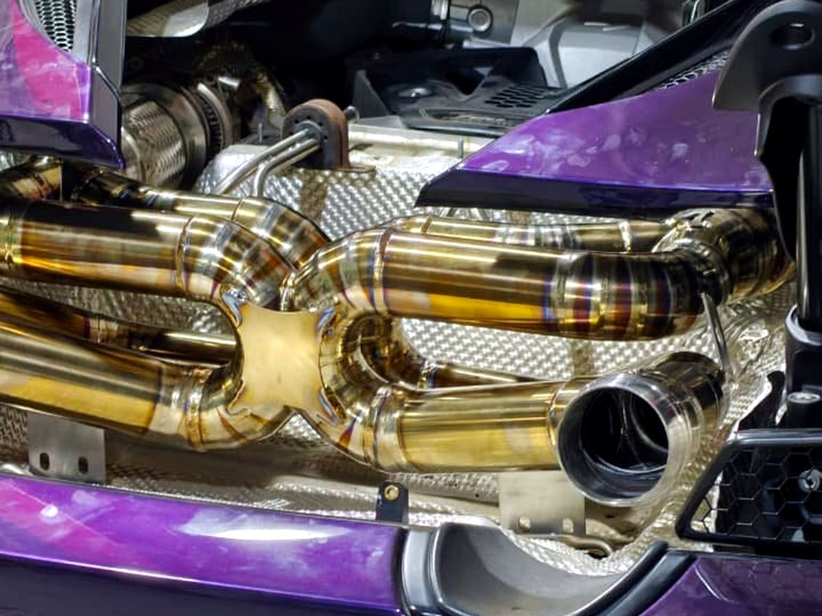 McLaren 720S rear bay with OUCHI titanium dual X-pipe and heat shielding — customer installation