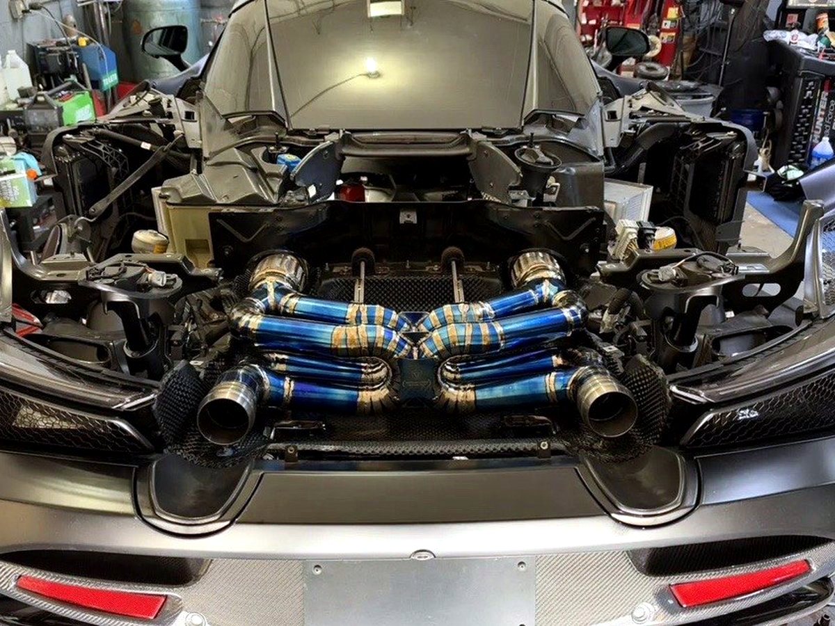McLaren 720S with OUCHI titanium dual X-pipe exhaust in gold tint, rear deck open — customer installation