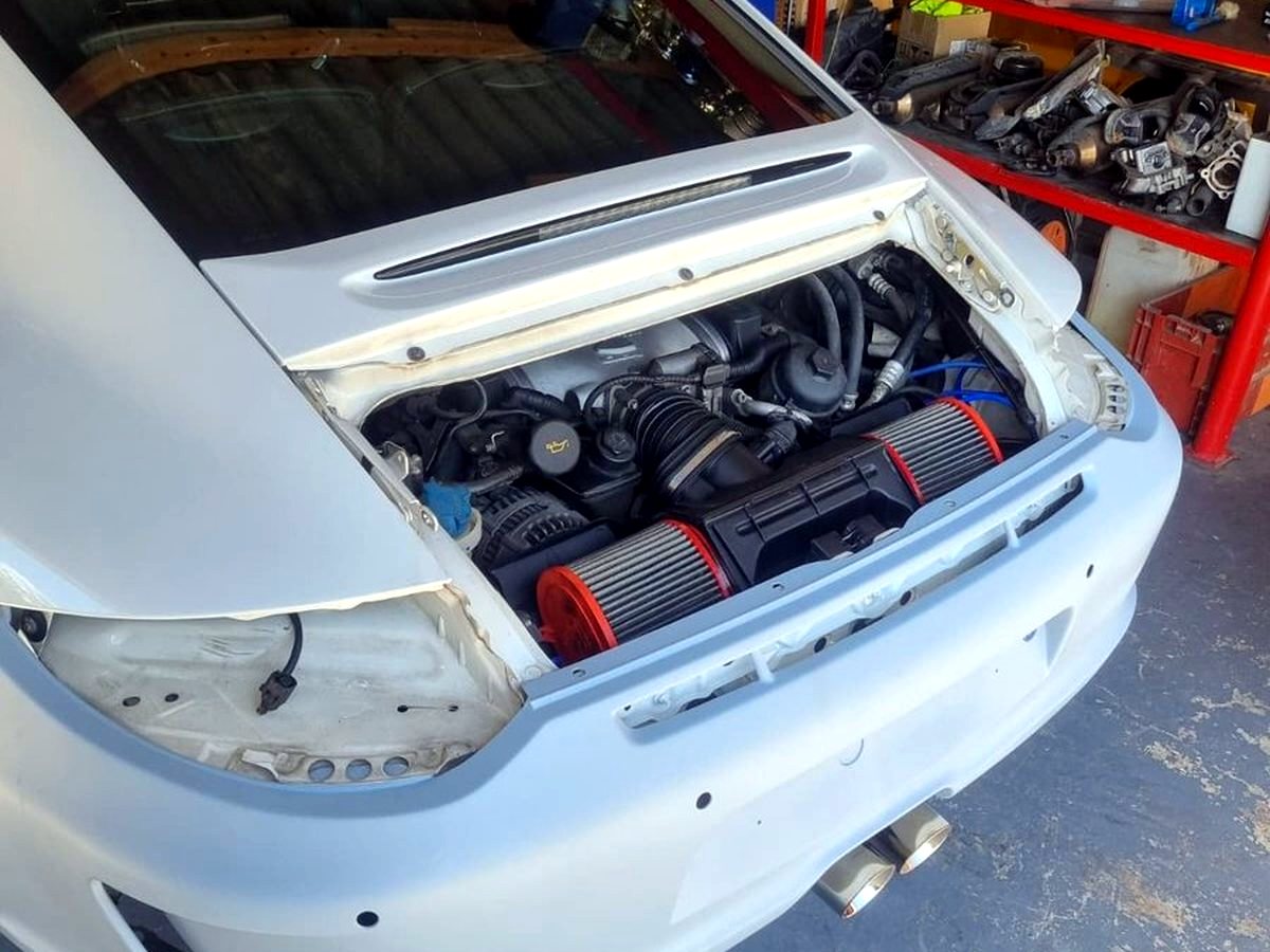 Earlier-generation 911 in the shop with OUCHI exhaust fitted — customer installation