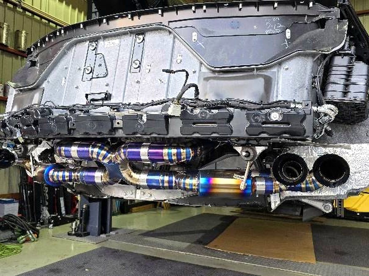 Corvette C8 on the lift with OUCHI TC4 titanium valved rear system, burn-tinted — customer installation