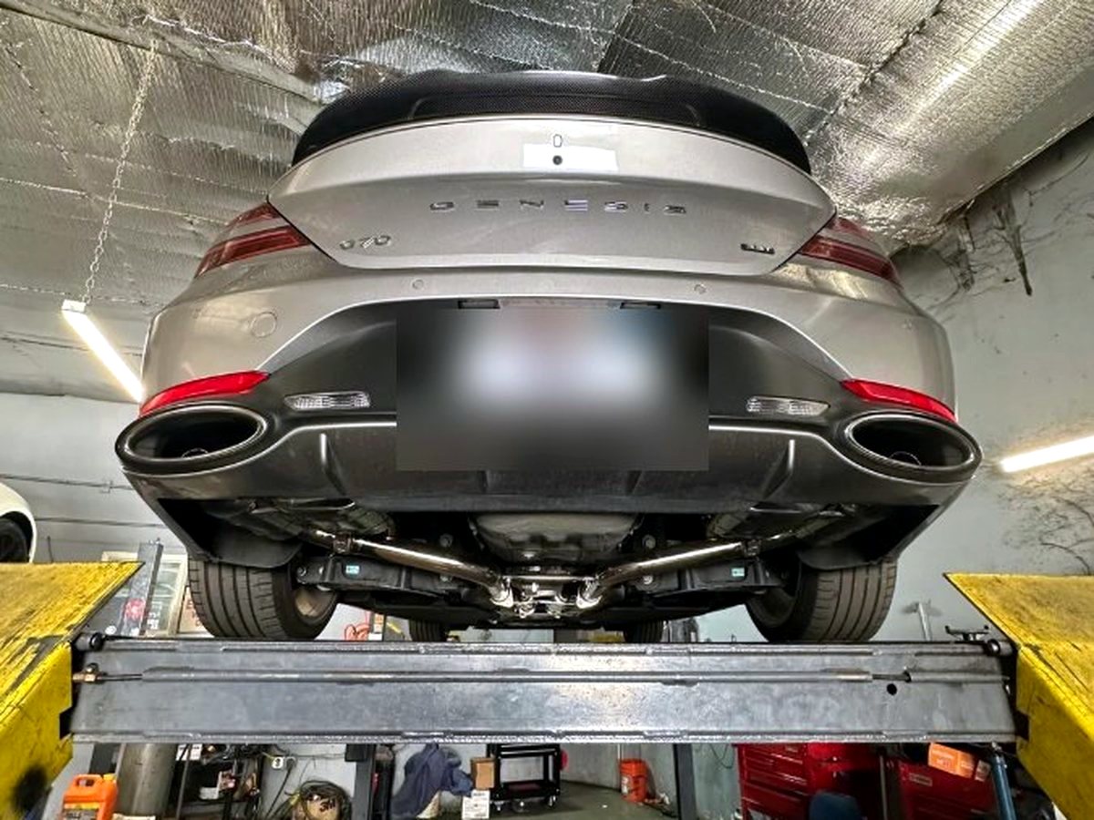 Genesis G70 3.3T rear on the lift with OUCHI T304 stainless exhaust fitted — customer photo