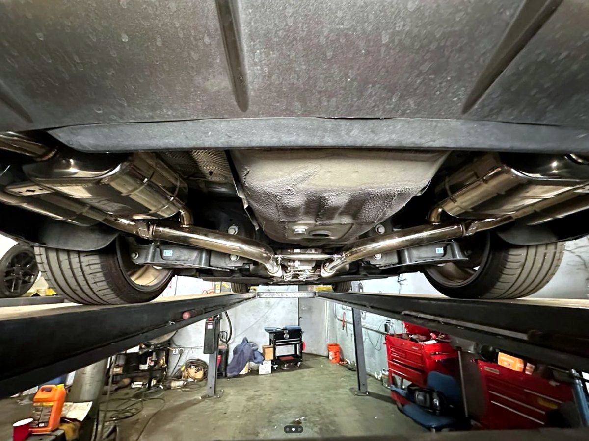 Genesis G70 underbody with OUCHI T304 stainless quad-outlet exhaust — customer installation