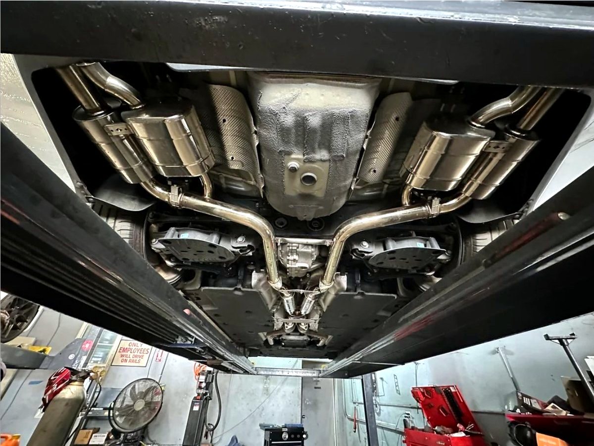 Genesis G70 underbody — OUCHI T304 stainless exhaust with quad mufflers, symmetrical routing — customer installation