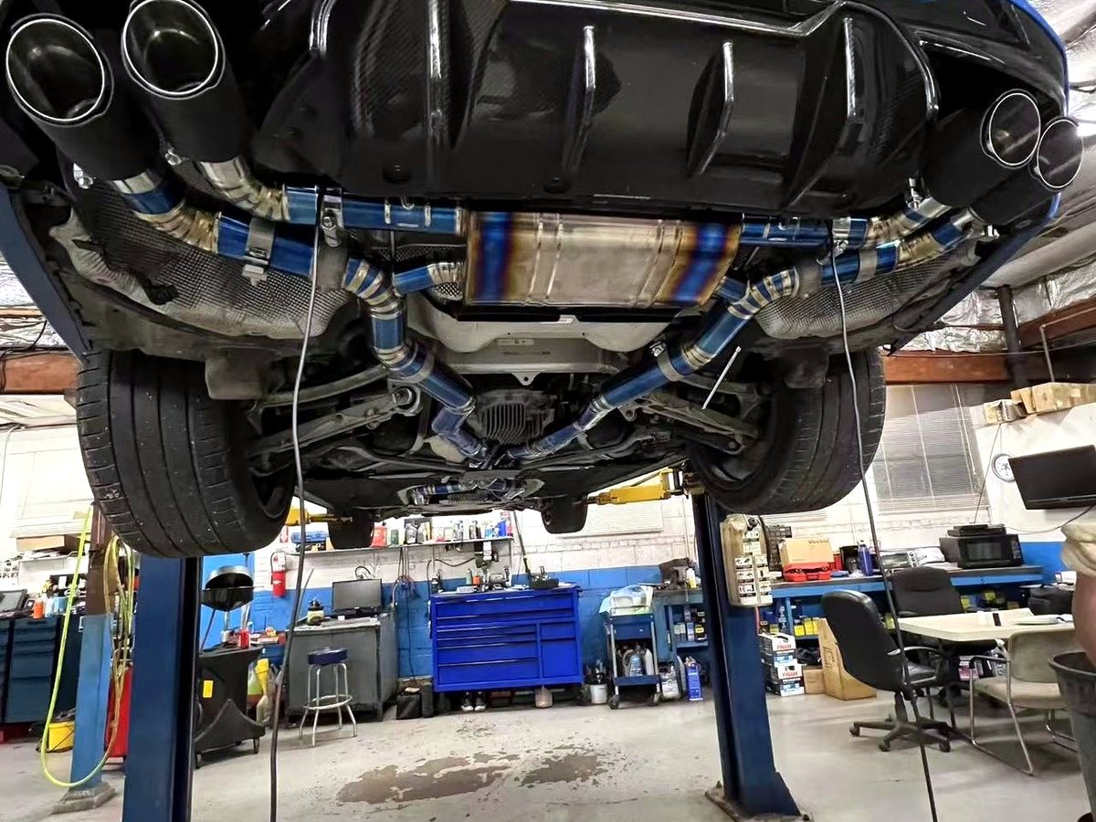 BMW M5 rear with OUCHI titanium valved exhaust and heat-tinted mid section — customer installation
