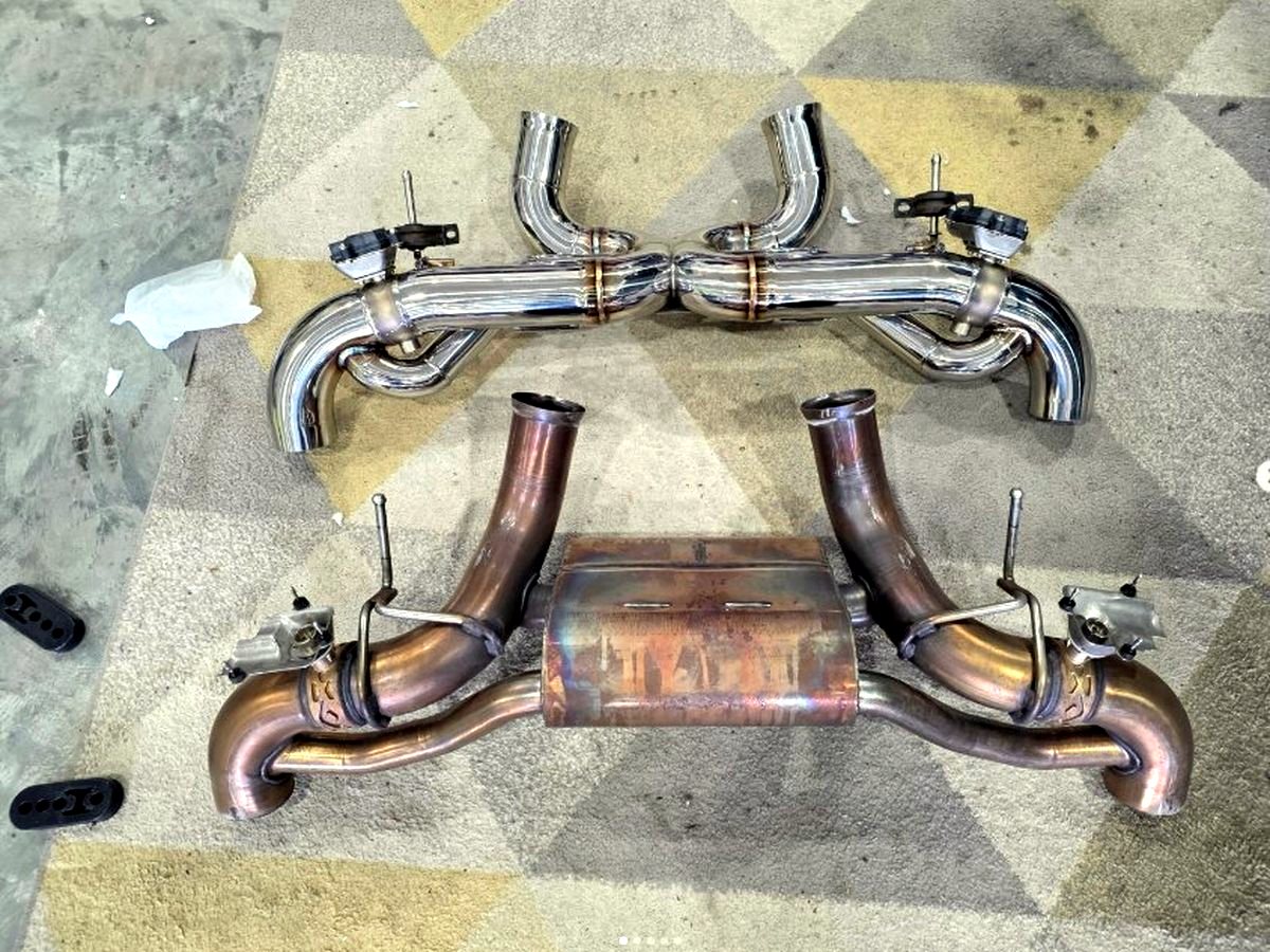 McLaren GT — OUCHI stainless valved system next to the stock exhaust — customer installation