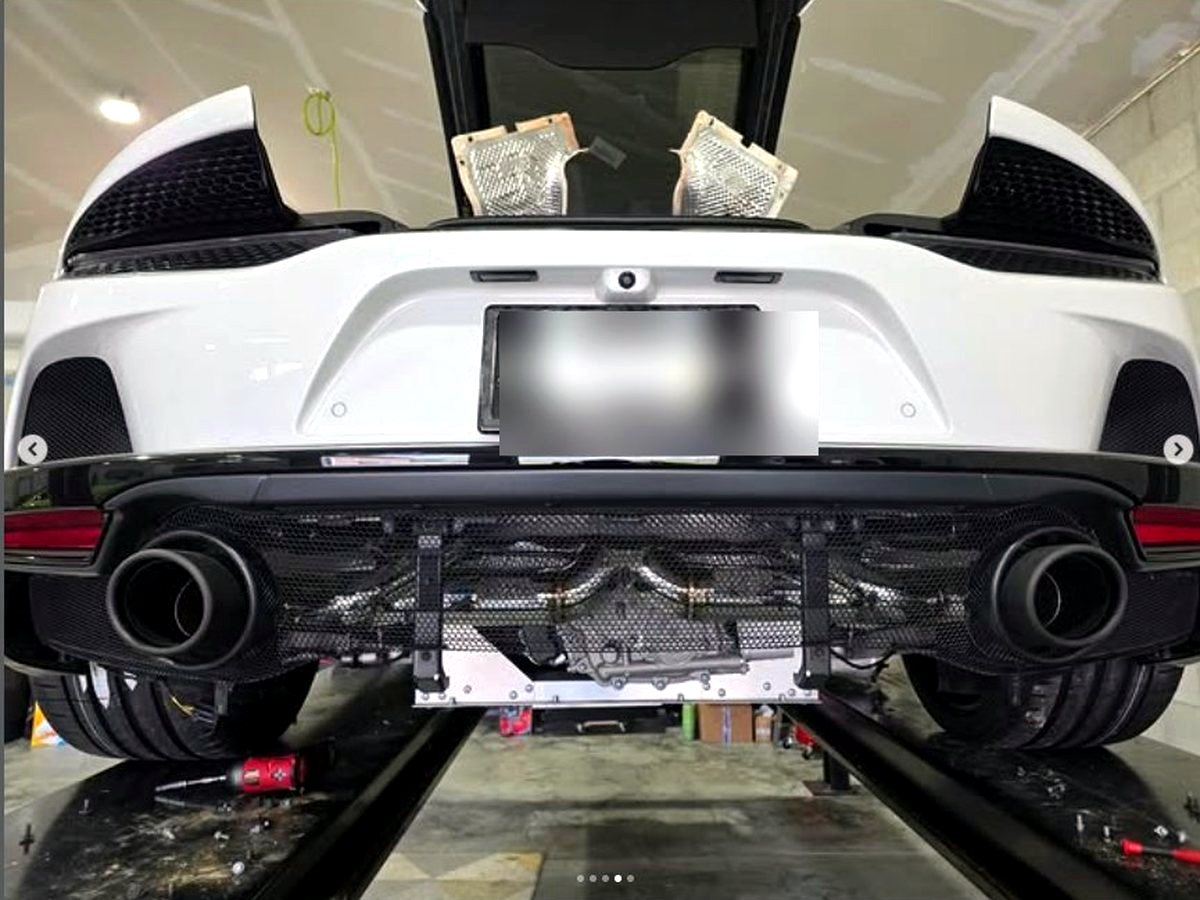 McLaren GT rear on the lift with OUCHI T304 stainless valved exhaust fitted — customer installation