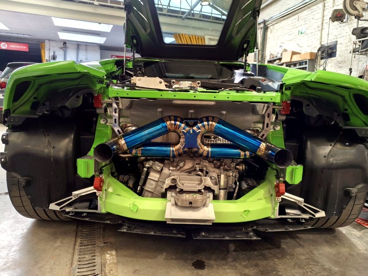 Lamborghini Huracan Tecnica in verde with OUCHI blue heat-tinted titanium exhaust, V10 bay top view — customer installation