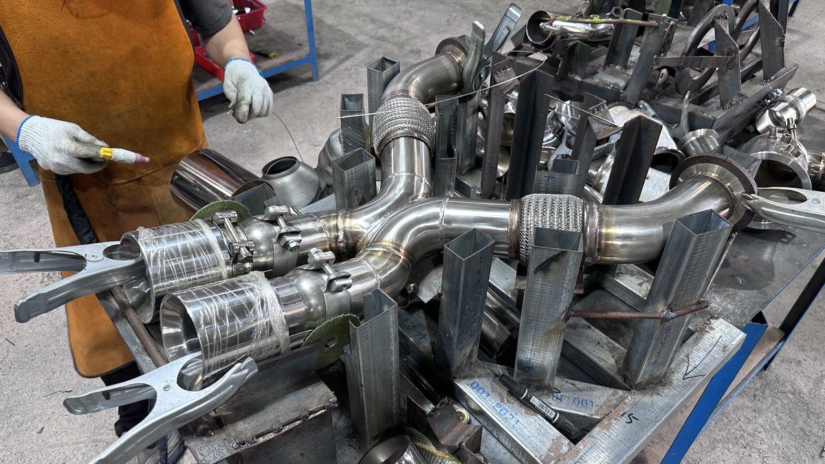 Technician marking and inspecting a finished exhaust header