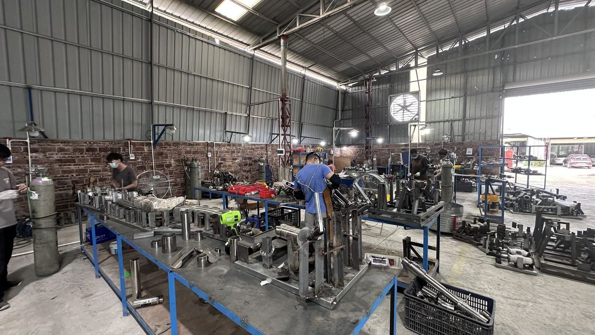 Stainless steel exhaust systems held in welding jigs
