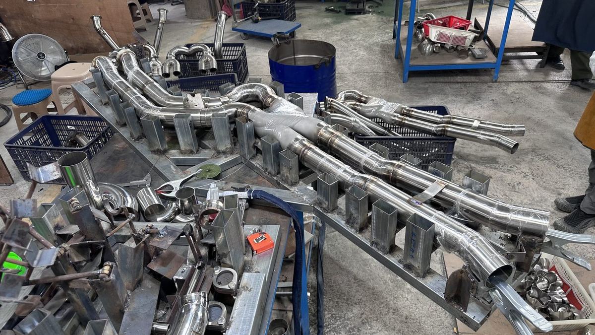 OUCHI production floor: welding stations and exhaust jigs in Meizhou
